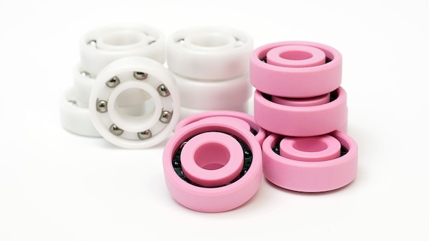 Weißes und rosa Kunststoffkugellager auf weißem Hintergrund