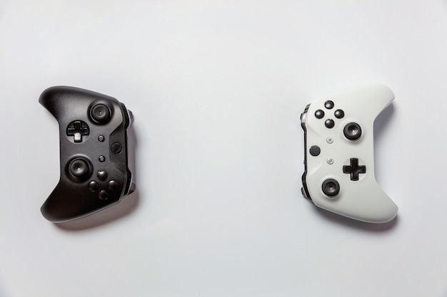 Foto weißes und schwarzes zwei joystick-gamepad, spielekonsole lokalisiert auf weißem hintergrund