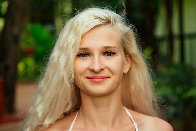 Weißhäutige, nicht gebräunte Frau, verlängerte Wimpern, Blick in die Kamera, junges Mädchen am tropischen Strand