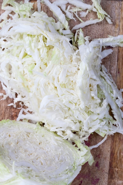 Foto weißkohl in stücke geschnitten, in scheiben geschnitten und zum kochen gehackt