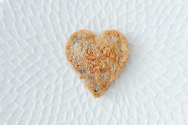 Weißrussisches Nationalgericht - Kartoffelpuffer. Herzform auf einem schönen weißen Teller gemacht.