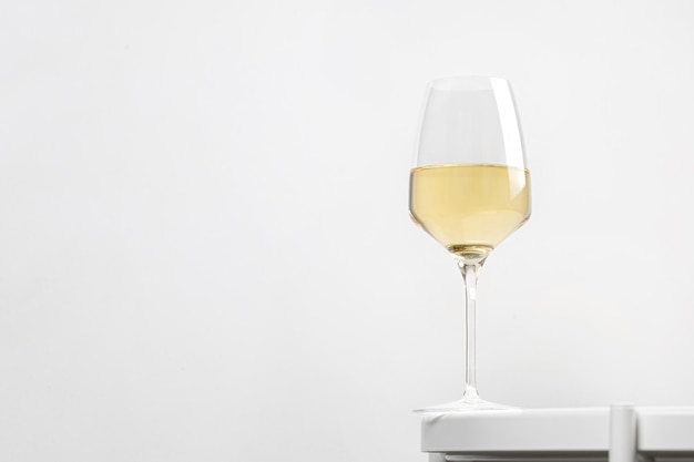 Weißwein im reichen Glas auf einem weißen runden Tisch. Minimalismus. Elegant