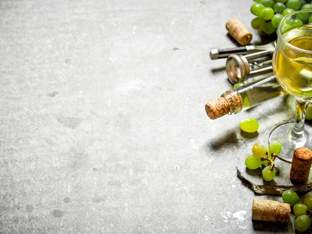 Weißwein in Flasche und Glas. Auf dem Steintisch.