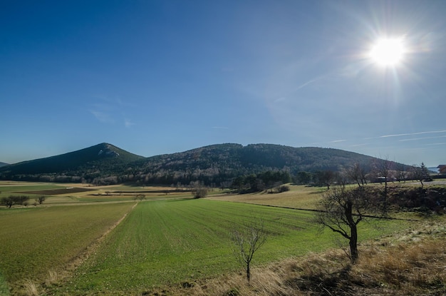 Weite Landschaft mit Bergen und Sonne