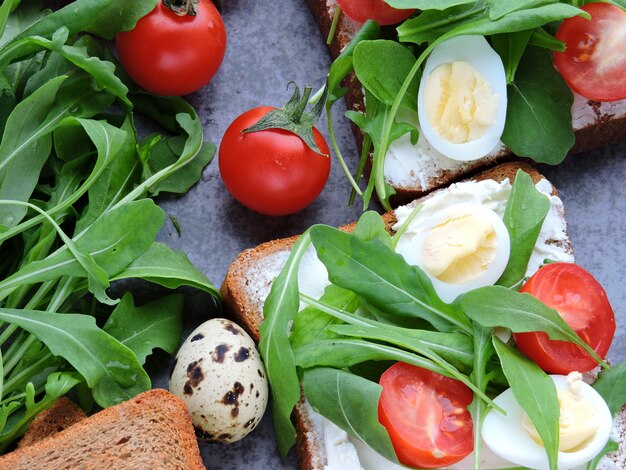 Weizen-Roggen-Toast mit Rucola, Wachteleiern und Kirschtomaten.