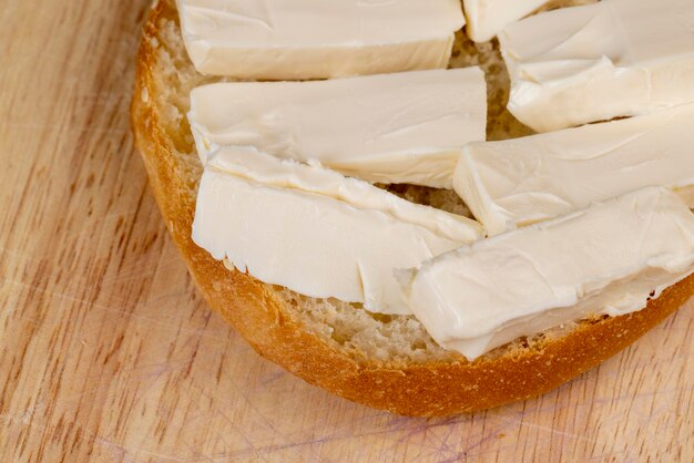 Weizenbrötchen mit großen Schmelzkäsestücken im Inneren, weiches und frisches Brötchen in Stücke geschnitten