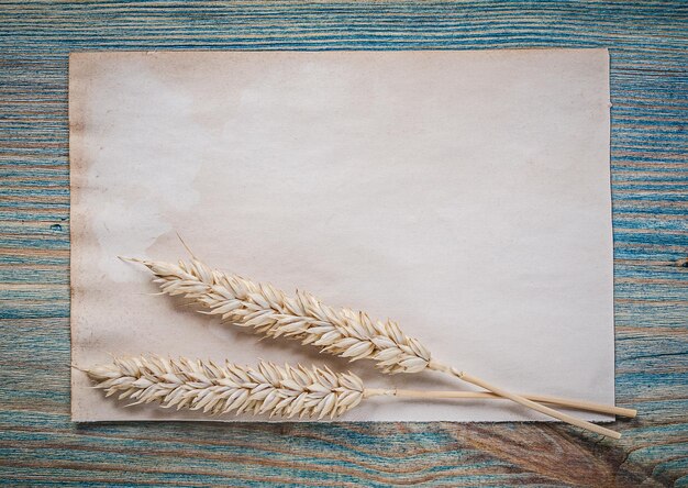 Foto weizenroggen-ohren-blatt papier auf vintage-holzbrett