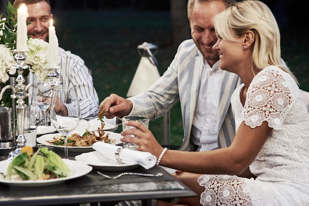 Welch ein schönes Paar. Eine Gruppe erwachsener Freunde ruht sich abends im Hinterhof des Restaurants aus und unterhält sich.