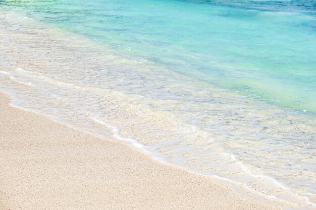 Welle des blauen Ozeans am weißen Sandstrand