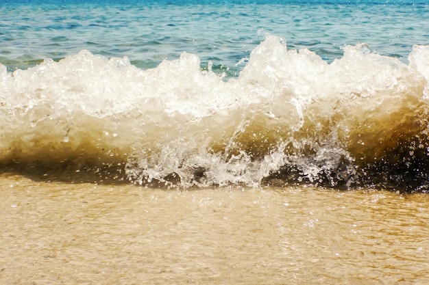 Welle des blauen Ozeans auf sandigem Strand-Sommer-Hintergrund