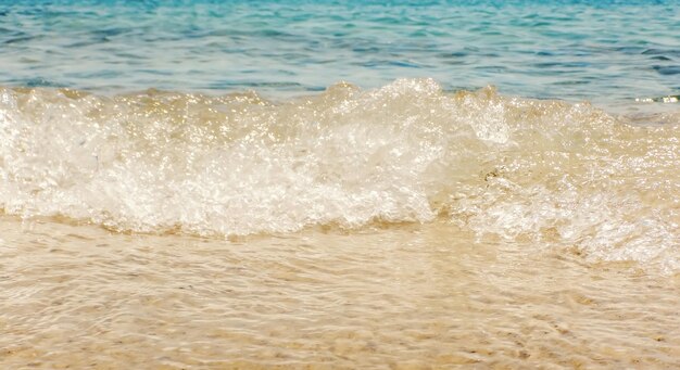 Welle des blauen Ozeans auf sandigem Strand-Sommer-Hintergrund