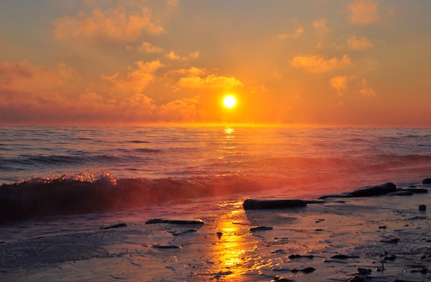 Wellen brechen am Strand gegen einen bewölkten Himmel in der Dämmerung