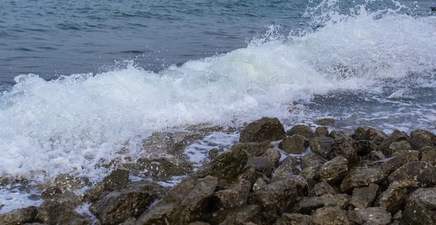 Wellen brechen auf einem steinigen Strand