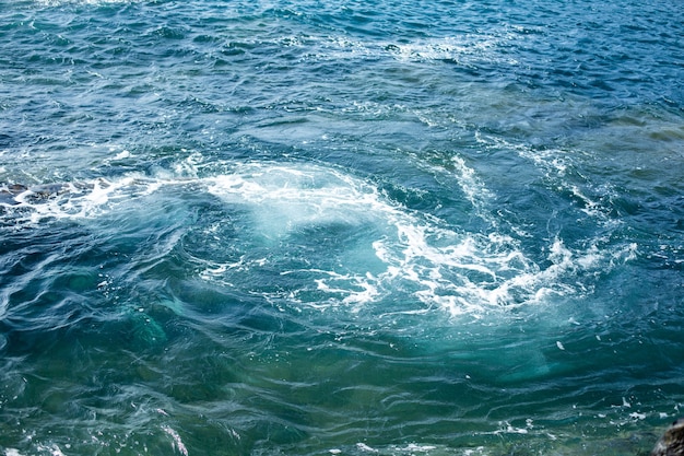 Wellen des Atlantischen Ozeans plätschern über die gekühlte Lava auf der spanischen Insel Lanzarote.