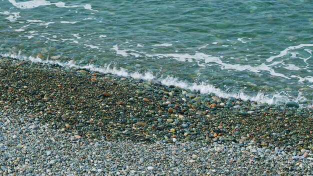 Foto wellen laufen an der küste kieselsteine ozeanwellen am strand strand mit kieselsteinen, die die wellen zum