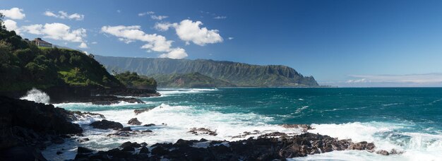 Wellen schlagen in Queens Bath Kauai auf Felsen