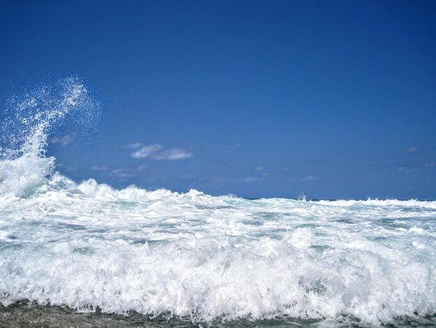 Wellen spritzen auf dem Strand