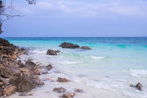 Wellenmeer am Sandstrand mit Stein oder Felsen an der Küste mit blauem Himmelshintergrund. Bucht Insel Meerblick Natur Meereslandschaft in Thailand. tourismusurlaub tropischer reisesommer im urlaubskonzept.