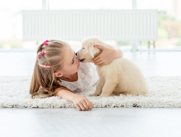 Welpe, der kleines Mädchen küsst