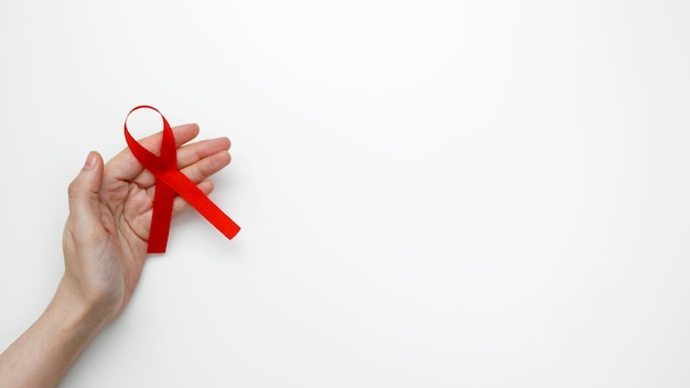 Welt-Aids-Tag Frau hält ein rotes AIDS-Bewusstseinsband