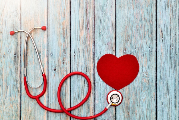 Weltgesundheitstag, Gesundheitswesen und medizinisches Konzept, rotes Stethoskop und rotes Herz auf dem blauen hölzernen Hintergrund