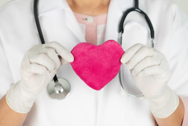 Weltherzgesundheitstagkonzept und Krankenversicherung des Gesundheitswesens mit Arzt mit Stethoskop, das rotes Herz hält