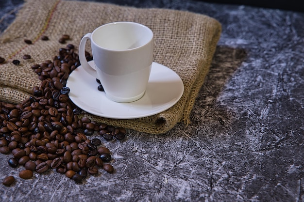 Weltkaffeetag Konzept weiße Porzellantasse mit Kaffeebohnen