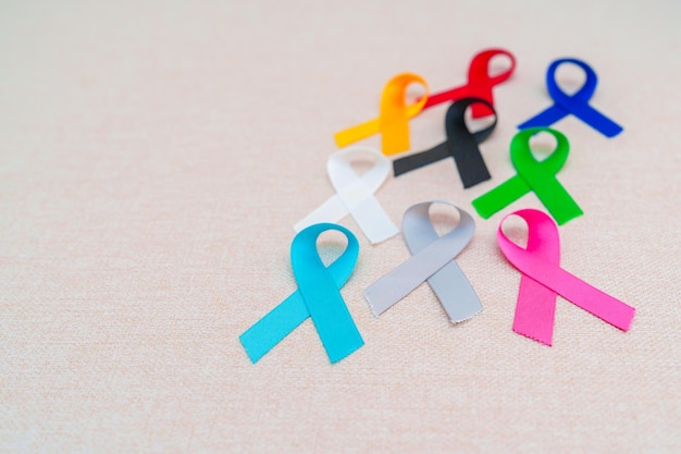 Weltkrebstag 4. Februar Bunte Bänder zur Unterstützung von Menschen, die leben und Krankheit Gesundheitswesen bekämpfen medizinische und National Cancer Survival Day Autism Awareness Day Konzept