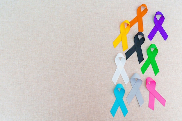 Weltkrebstag 4. Februar Bunte Bänder zur Unterstützung von Menschen, die leben und Krankheit Gesundheitswesen bekämpfen medizinische und National Cancer Survival Day Autism Awareness Day Konzept