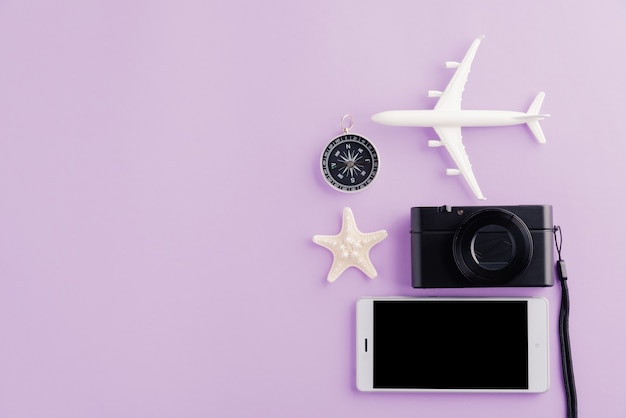 Welttourismustag Modellflugzeug Flugzeug Seestern Wecker Kompass und Smartphone leerer Bildschirm