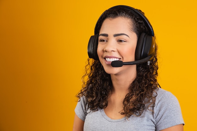 Wenden Sie sich an den Callcenter-Service. Kundenbetreuung, Verkäuferin. Anrufer oder Betreiber von Telefonisten oder Geschäftsfrauen im Headset. Afro-junge Frau. Zoom-Konferenz. gelber Hintergrund