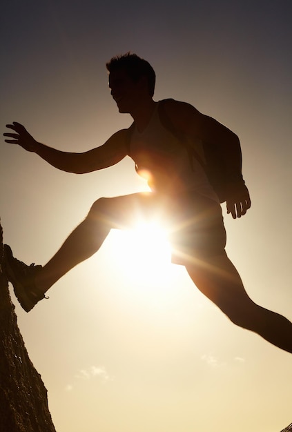 Wenn das Abenteuer ruft, antwortet die Silhouette eines Mannes, der über Felsen springt