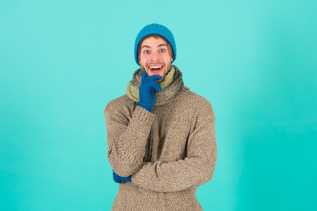 Wenn das Wetter kalt wird. Glücklicher Mann im blauen Hintergrund der Winterart. Hübscher Kerl im lässigen bequemen Stil. Wintermode und Accessoires. Halten Sie sich mit Stil warm. Es ist einfach, Ihren Stil beizubehalten.