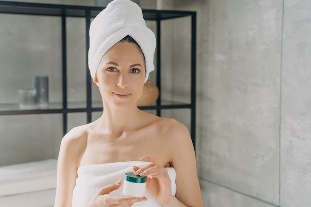 Werbebanner für Gesichtscreme Mädchen nach dem Baden und Haarewaschen mit Glas in Handtuch gewickelt