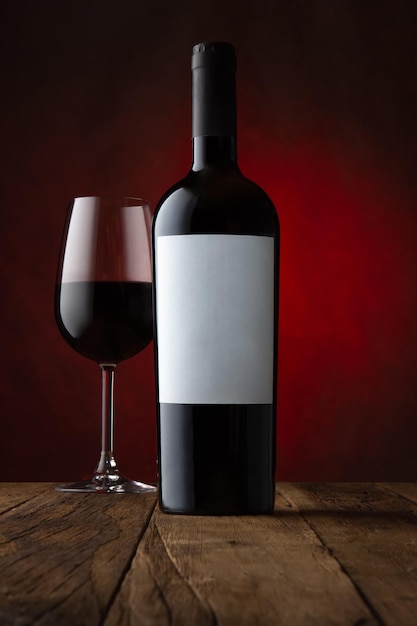 Werbefoto von Glas und Flasche Rotwein mit leerem Etikett und einem rostigbraunen Hintergrund-Mockup