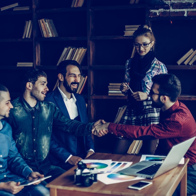 Werbeleiter mit Handschlag begrüßt den Kunden in einem modernen Büro