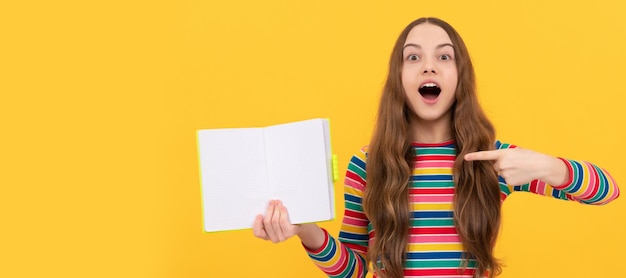 Werfen Sie einen Blick, lesen Sie ein Buch. Überrascht, Mädchen zeigen mit dem Finger auf offenes Buch