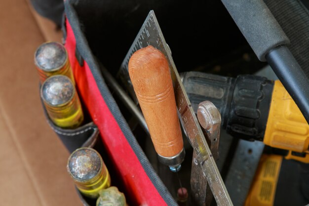 Werkzeuge im Taschenarbeitstag und im Geschäftskampf, der Werkzeuge auf einer Arbeitstabelle in Handarbeit macht.