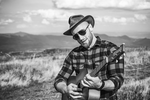 Western-Cowboy-Männer spielen auf der Gitarre Lifestyle-Wanderkonzept