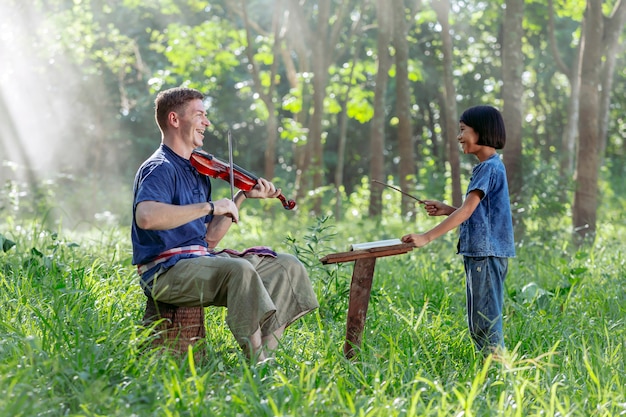 Westmann, der die Violine mit thailändischen Mädchen spielt