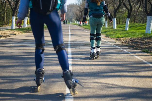 Wettbewerbe im RollschuhlaufenZwei Mädchen auf Rollschuhen fahren die Straße entlang