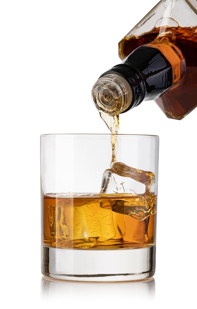 Whiskey derramado num copo de uma garrafa