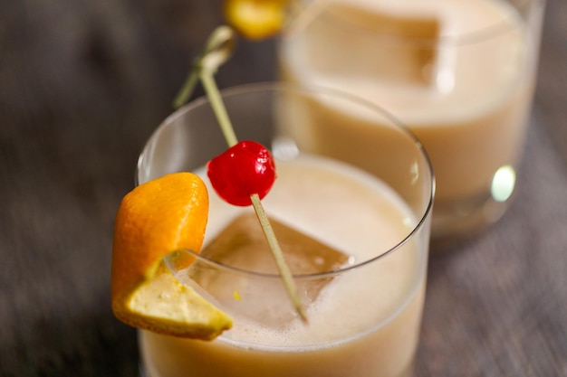 Whiskey-Sauer-Cocktail garniert mit Orange und Kirsche.