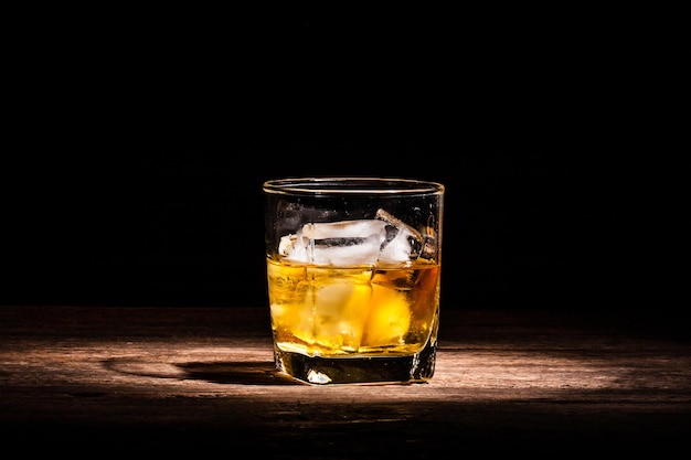 Whiskey und Eis im Glas auf dem Tisch aus nächster Nähe