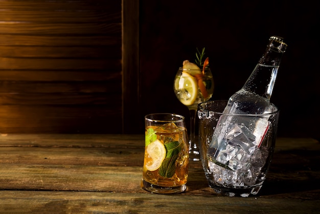 Whisky basierte Cocktail mit Glas Eiseimer auf dunklem hölzernem backgorund