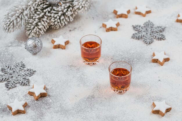 Whisky, brandy o licor, galletas y adornos navideños en blanco