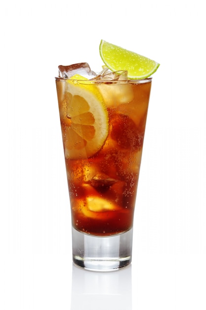 Foto whisky del cóctel con cola, hielo, limón y cal en el vidrio de highball aislado en blanco.