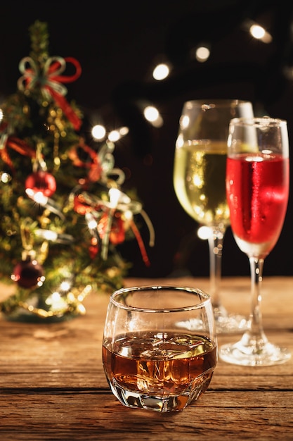 Whisky y cóctel en Navidad en mesa de madera.