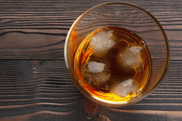 whisky con cubitos de hielo en madera