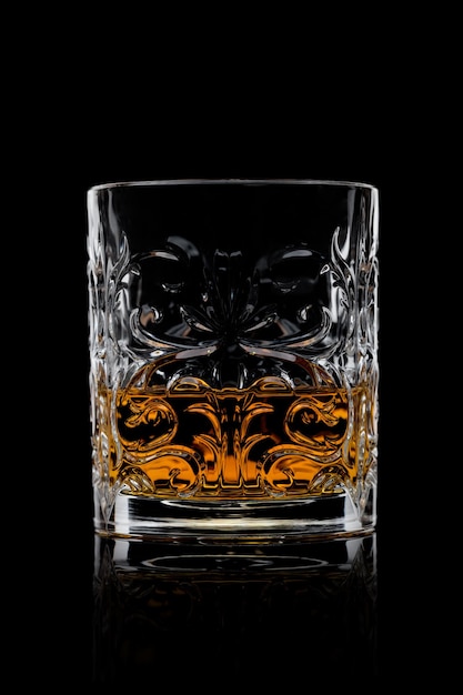 Whisky escocés en cristal elegante sobre fondo negro con reflejo